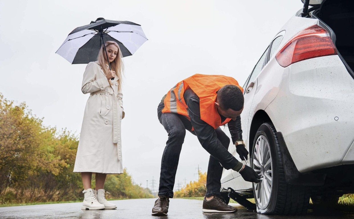 Professional roadside assistance technician changing flat tire in Bountiful, UT