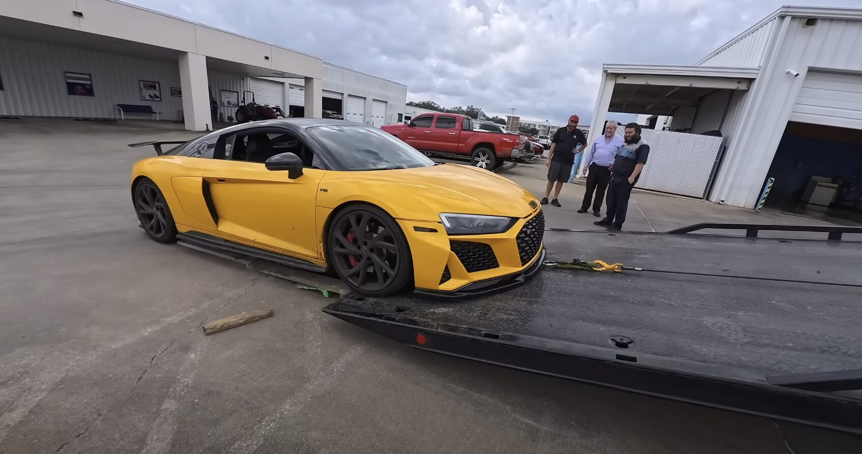 Luxury car being loaded onto flatbed tow truck for safe transport